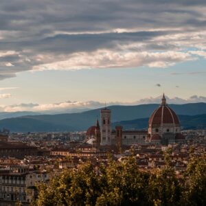 Stunning Florence cityscape featuring the iconic Florence Cathedral and Palazzo Vecchio against a mountainous backdrop.