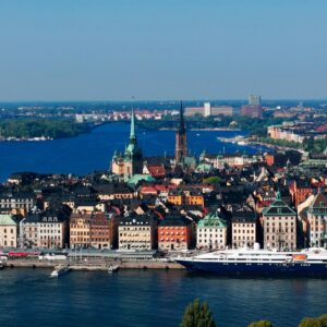 Scenic aerial view of Stockholm's colorful buildings and harbor under clear blue skies.