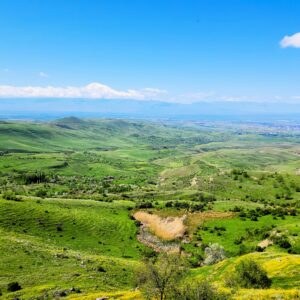 Explore the vibrant landscapes of Voghjaberd, Armenia with lush green hills and distant mountains.