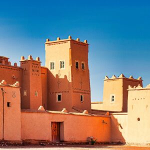 A stunning view of a traditional Moroccan fortress with distinct architectural features against a bright blue sky.